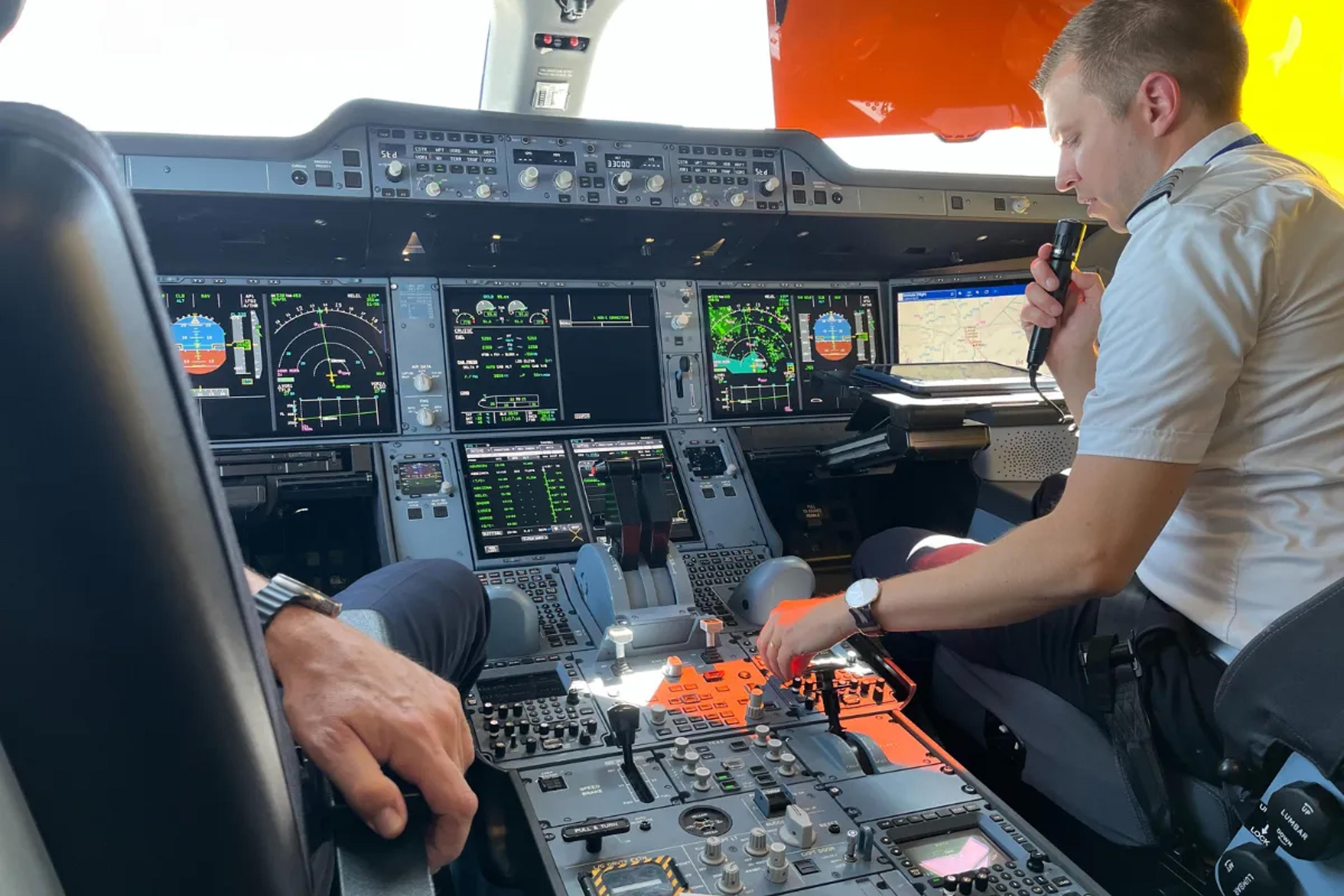 Pilot taler med en flyveleder i et cockpit.